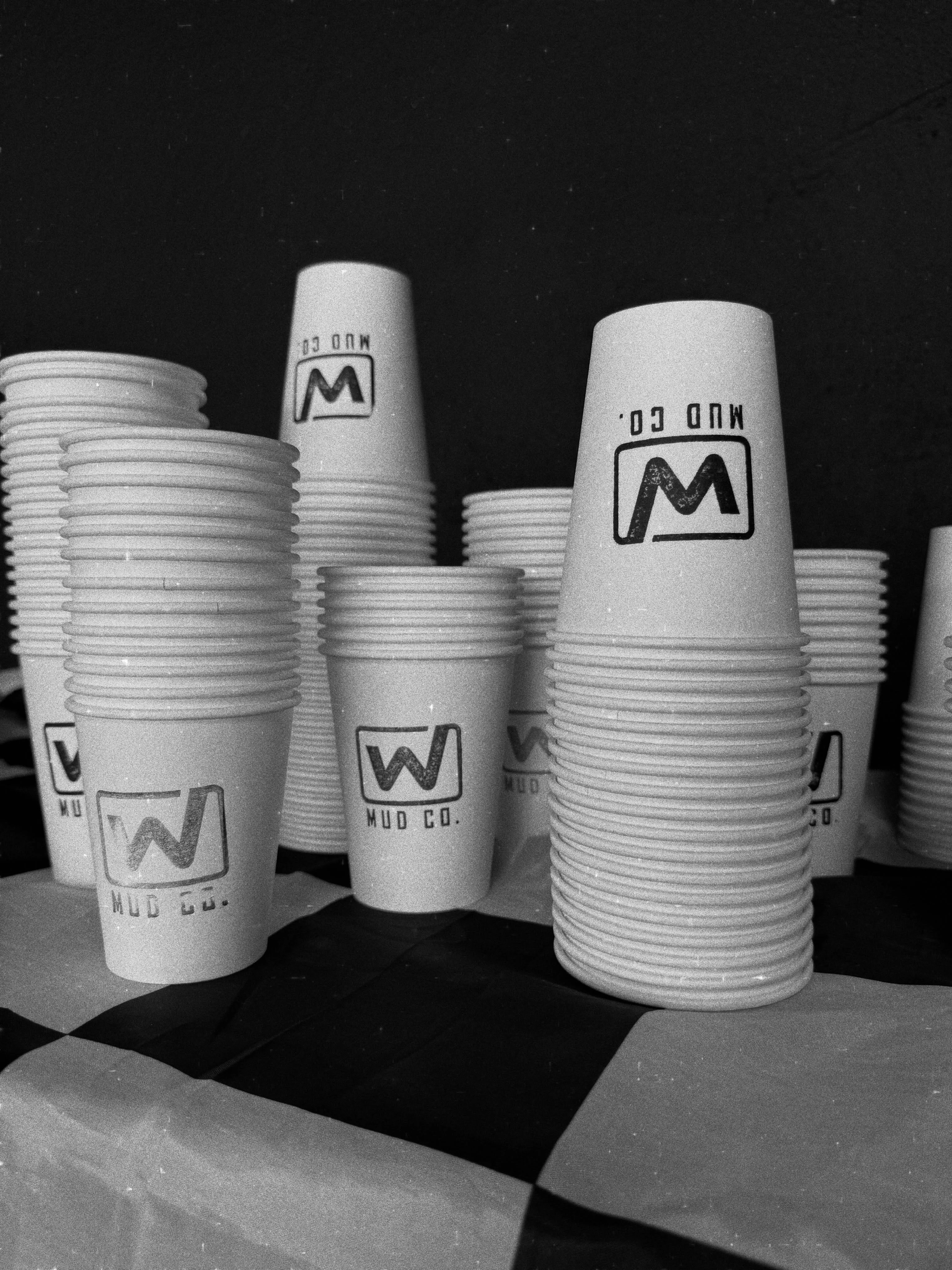 Stacks of coffee cups stamped with the Mud Co. logo