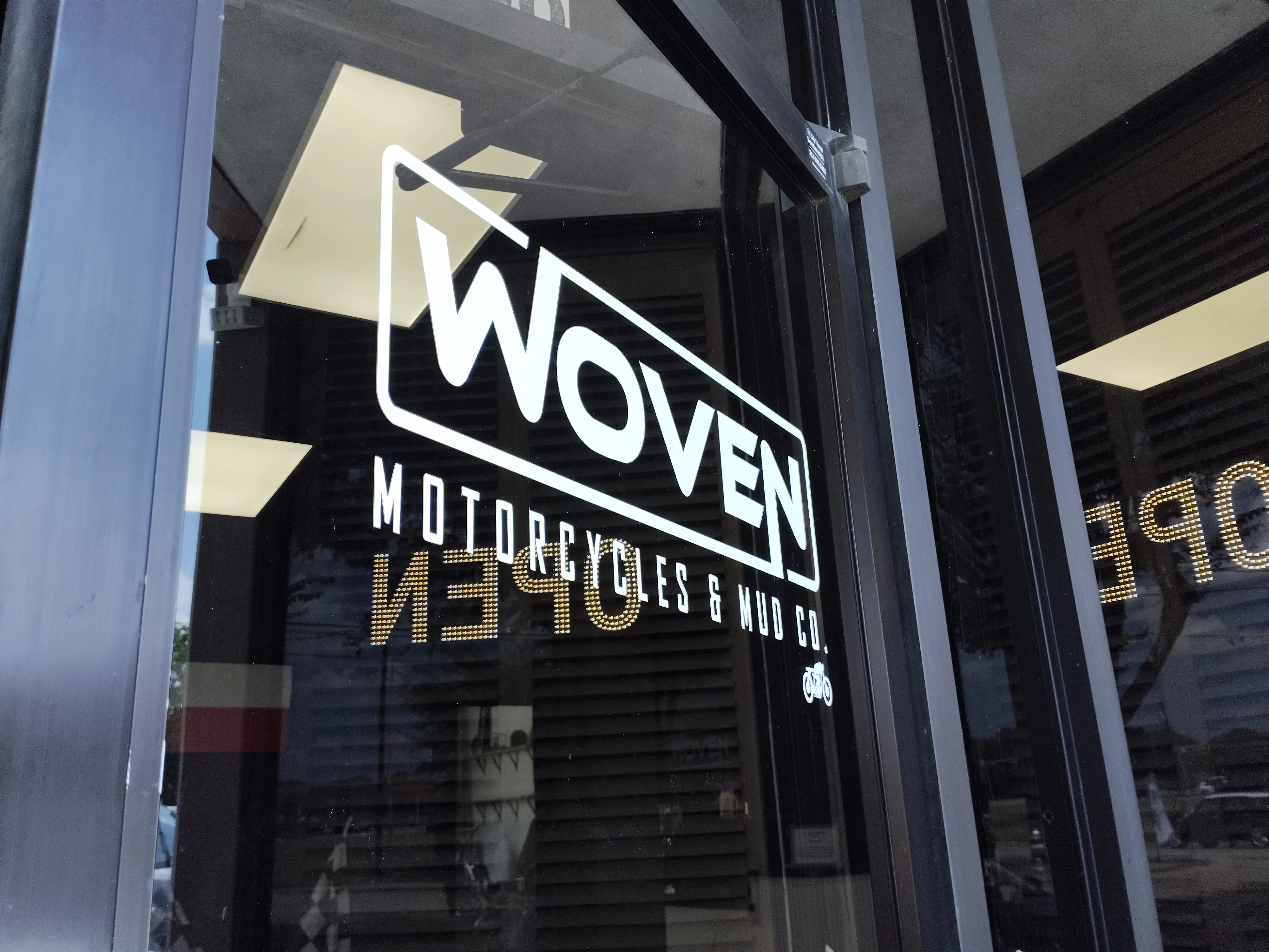 Exterior of a motorcycle shop with a van parked out front