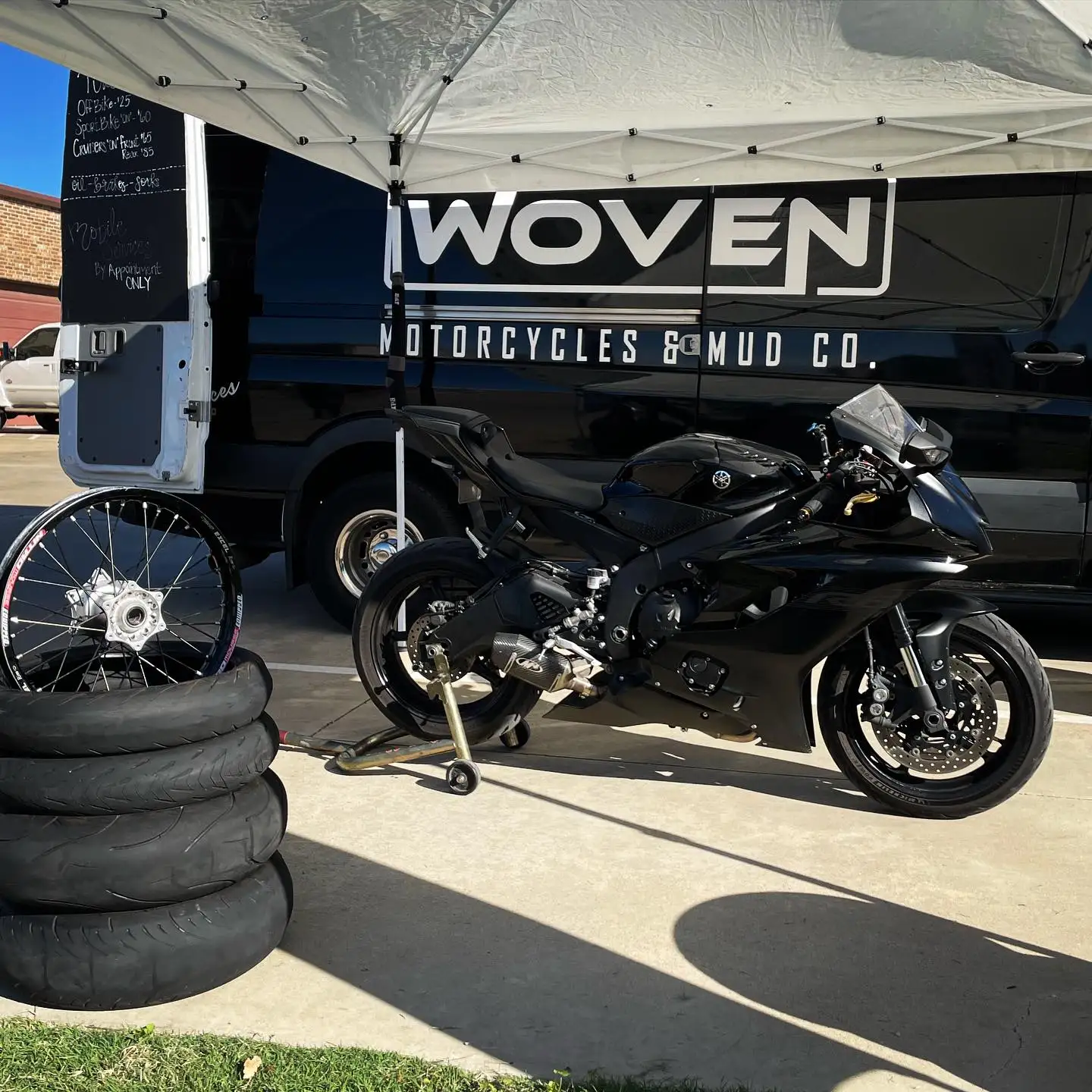Custom motorcycle on a shop lift with a van in the background
